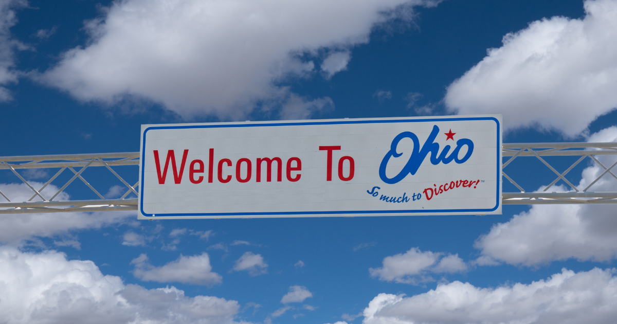 Overpass sign with blue sky background welcoming people to Ohio